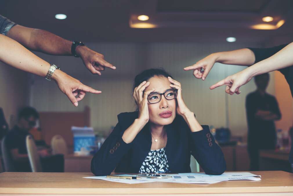 Frustrated business woman sitting at the table in office.