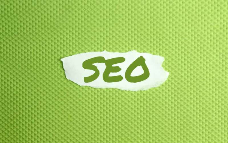 a torn paper written with inscription SEO on a green background
